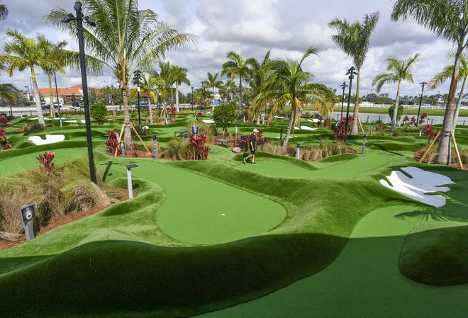 A PopStroke staff member checks the twin 18-hole putting courses on Tuesday, Oct. 11, 2022, in the Tradition development in Port St. Lucie. PopStroke reopened Saturday, Oct. 8, 2022, with redesigned courses by TGR Design, the addition of a playground and a revamped menu in the restaurant.