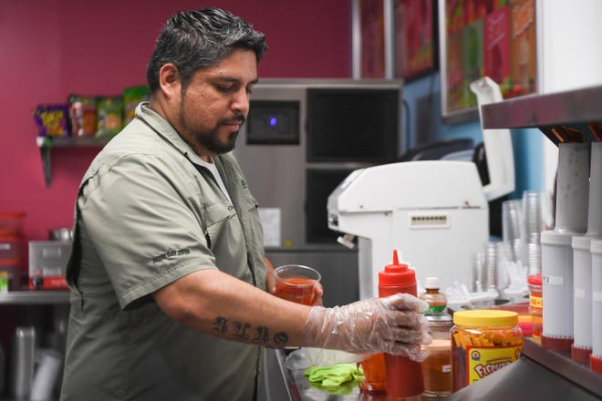 Juan Nuno prepares one of Fruteria Nuno's most popular items, the mangonada, Wednesday, July 20, 2022 in Fellsmere. The frozen drink consists of shaved ice, mangos, mango nectar, Tajín, chamoy and a tamarind candy straw. The homemade Mexican ice cream store in Fellsmere features Mexican snacks, treats, fresh produce and a supermarket.
