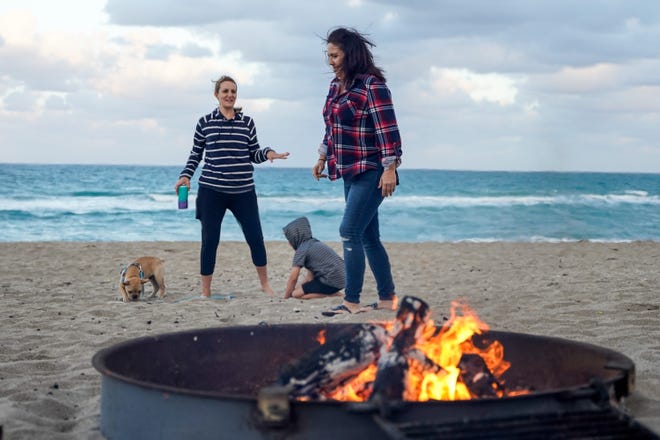 Beachgoers enjoy fire pits at Stuart Beach on Sunday, Feb. 20, 2022, on Hutchinson Island in Martin County. Beach fires can be held at designated fire pits from November to February with a permit purchased through Martin County Parks and Recreation.