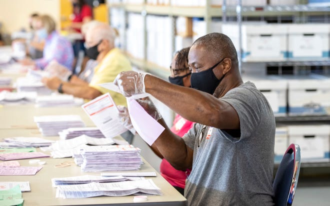 Elections staff open and process mail ballots on Sunday, Oct. 11, 2020, at the Indian River County Supervisor of Elections office in Vero Beach, Fla. Workers were processing 21,133 ballots. "It's very labor intensive and we've never had that many ballots at the initial opening before," said elections supervisor Leslie Rossway Swan (not pictured).