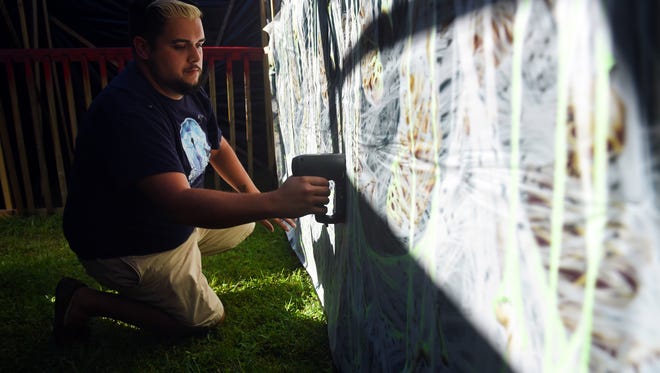Jacob Blake, of Port St. Lucie, puts up decorations along the path of his haunted house, Mercy Asylum, Thursday, Oct. 26, 2017, at his home in Port St. Lucie. This will be the 13th year Blake has put on his haunted house. "This year it's definitely going to be a more intimate haunt with only two people allowed through the house at a time," Blake said. There is a $3 minimum donation to enter the house, and all proceeds will go to the Make-A-Wish Foundation. "When I was younger, I was nominated as a Make-A-Wish kid, and I got to meet Cher. That had such a major impact on my life that I knew that I wanted to make sure that other children get the same opportunity I did," Blake said. Mercy Asylum will be open Oct. 28-31 starting at 7:30 p.m. and going until midnight.