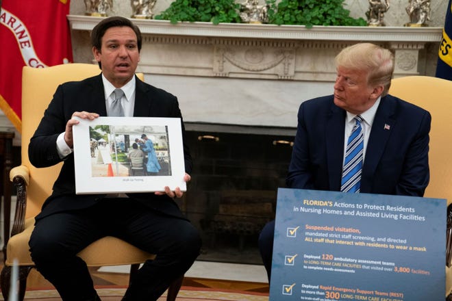 President Donald Trump listens as Gov. Ron DeSantis, R-Fla., talks about the coronavirus response during a meeting in the Oval Office of the White House, Tuesday, April 28, 2020 in Washington.
