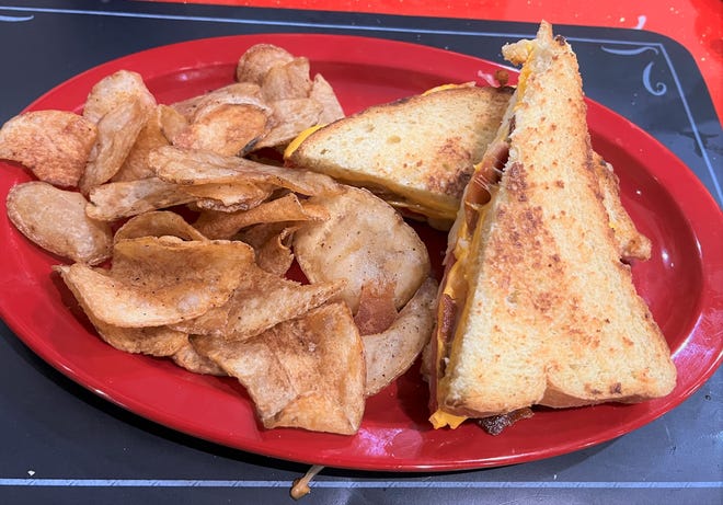 The loaded grilled cheese was American, cheddar, Swiss cheeses, bacon, and tomato piled high between two slices of Texas toast.