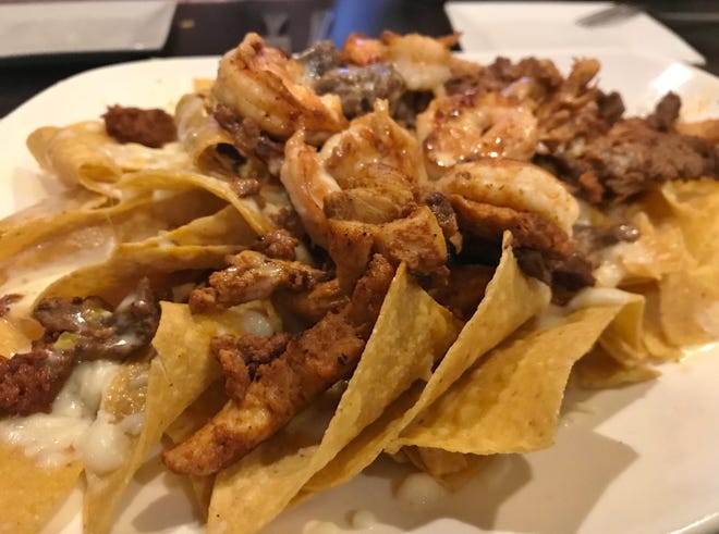 Casa Amigos Nachos were covered with shredded cheese, queso, grilled chicken, steak, chorizo, and shrimp.