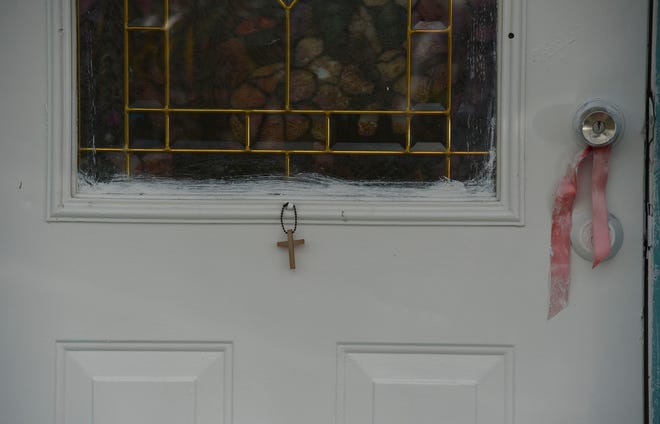 A cross hangs at the front door of the home where Donald L. Williams resides in Indiantown. Maribel Morales-Rosado, was shot at her home in Indiantown on Tuesday, Aug. 11, by Williams, her ex-boyfriend, according to Martin County Sheriff William Snyder, and died from her injuries.