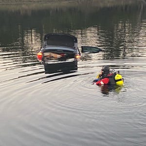 A Martin County Fire Rescue dive team member moves toward a car where sheriff's detectives rescued a woman from drowning December 14, 2022.