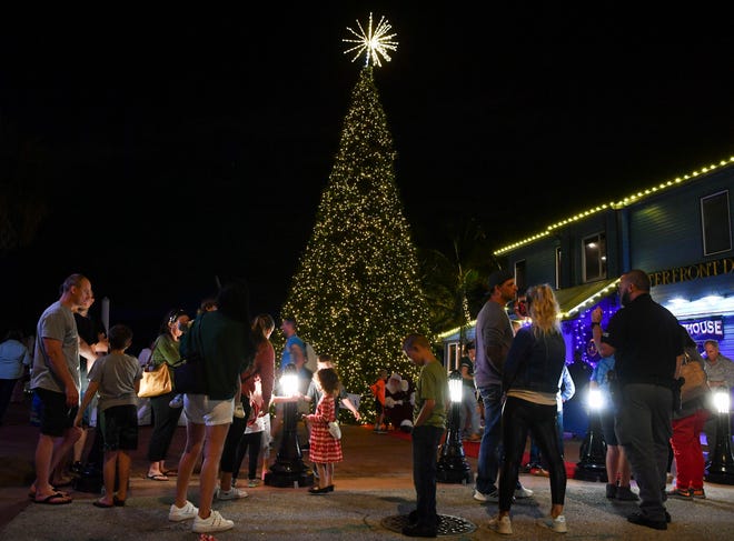 Families wait in line to see Santa Claus in front of the city's 30-foot Christmas tree, Thursday, Dec. 8, 2022, near the Riverwalk Stage in downtown Stuart.