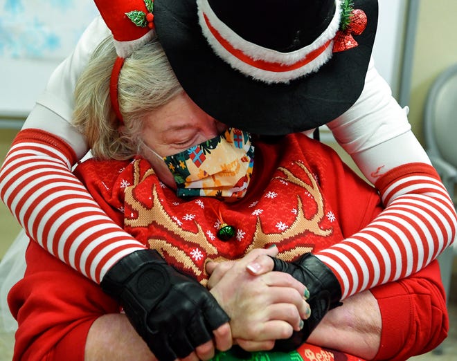 Wildflower Lady Riders founder Jennifer Vanhohenstein, of Hobe Sound, gives a hug to Michelle Ackley, 54, while visiting residents at Martin Coast Center for Rehabilitation and Healthcare on Saturday, Dec. 17, 2022, in Hobe Sound. Vanhohenstein said she started the Wildflower Lady Riders in 2017 after seeing a need for women motorcycle riders to have a sense of community and friendship. From September to December, the Lady Riders do back-to-back community events and ride their motorcycles to hand out care packages to people or to just make someone's day special.