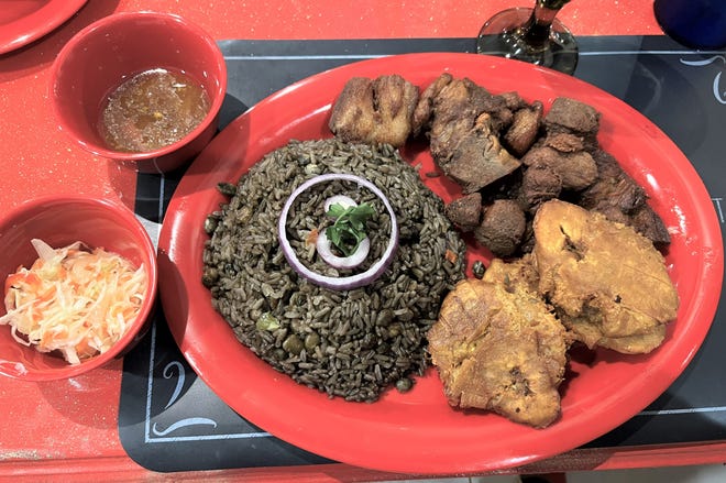 The griot is a Haitian dish of fried pork chunks, served with tostones and black beans, and rice. The special sauce makes the dish extra special.
