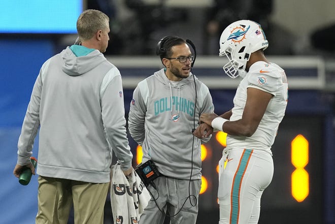 Miami Dolphins head coach Mike McDaniel, center, talks to quarterback Tua Tagovailoa during the second half of an NFL football game Los Angeles Chargers Sunday, Dec. 11, 2022, in Inglewood, Calif. (AP Photo/Mark J. Terrill)