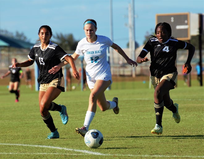 Treasure Coast defenders Angelina Carrero and Makaila Jackson and Jensen Beach forward Kate Frawley chase after a loose ball during a high school soccer match on Tuesday, Dec, 6, 2022 in Port St. Lucie. The Titans won the match 2-1.