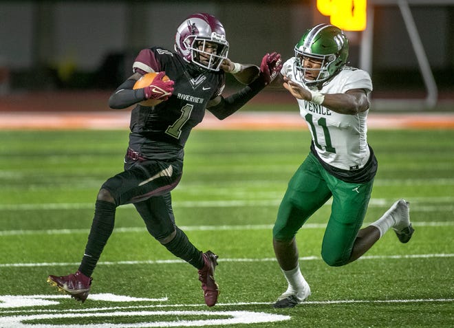 Riverview wide receiver Charles Lester III (1) tries to escape the grip of Venice defensive linebacker Damon Wilson (11) during their school's matchup up on neutral ground at Sarasota HIgh School. MATT HOUSTON/HERALD-TRIBUNE