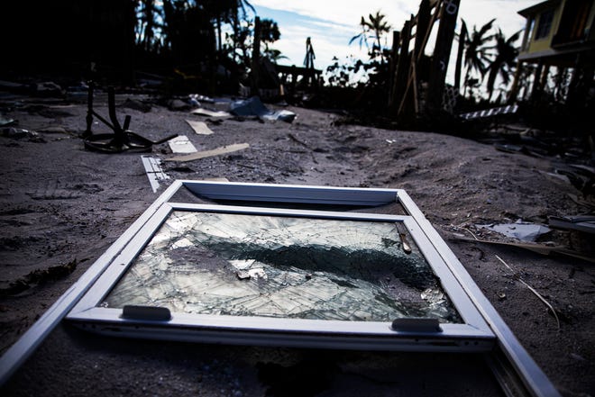 A shattered window lies in front of a destroyed Fort Myers Beach home on Nov. 23, 2022. The home was destroyed by Hurricane Ian. Signs of recovery can be seen all over the hurricane ravaged island while some areas of the beach are still untouched since Sept. 28.
