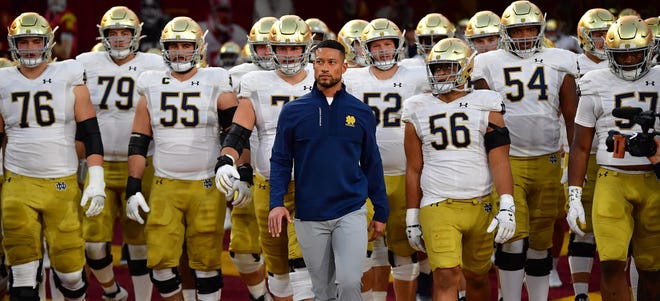 Notre Dame coach Marcus Freeman (center) led the Irish to victories in eight of their last 10 games, after an 0-3 start to his career that began in last year's Fiesta Bowl.