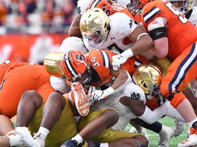 Notre Dame edge rusher Isaiah Foskey (7) tackles Syracuse running back Sean Tucker in a game on Oct. 29 at Syracuse. Foskey is the latest Irish player to opt out of the TaxSlayer Gator Bowl.