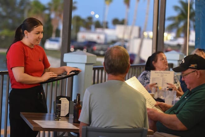 Cassidy Kutner (left), a server at Chuck's Seafood Restaurant, talks with her customers during dinner hours on Tuesday, Nov. 29, 2022, in Fort Pierce. "A lot of people live close here, so they save money on gas getting here, so it doesn't cost a lot getting to and from work to make the money to pay for the rent," she said. Restaurant workers, among others in the hospitality industry, are among the most affected finding affordable housing in today’s economy.