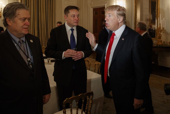 Then-President Donald Trump talking with Tesla and SpaceX CEO Elon Musk, center, and White House chief strategist Steve Bannon during a White House meeting with business leaders in February 2017.