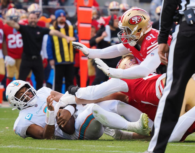 Dolphins quarterback Tua Tagovailoa is hit by 49ers end Nick Bosa (97) and Erik Armstead (91) during Sunday's loss.