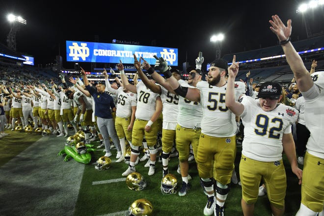 The Notre Dame Fighting Irish along with Notre Dame Fighting Irish head coach Marcus Freeman sing the School's Alma mater after their victory over South Carolina in the Gator Bowl.