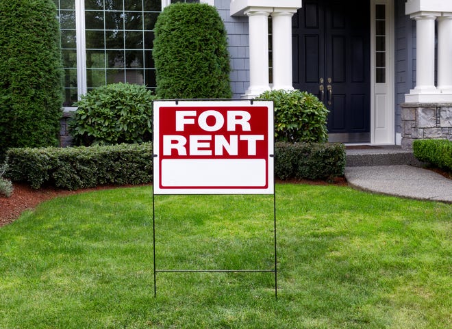 A sign in front of a home that says house for rent.