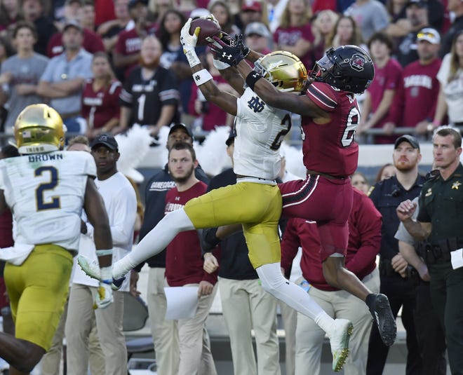 Notre Dame cornerback Benjamin Morrison (20) intercepts a pass intended for South Carolina wide receiver O'Mega Blake (89) during the second quarter of Friday's TaxSlayer Gator Bowl at TIAA Bank Field.