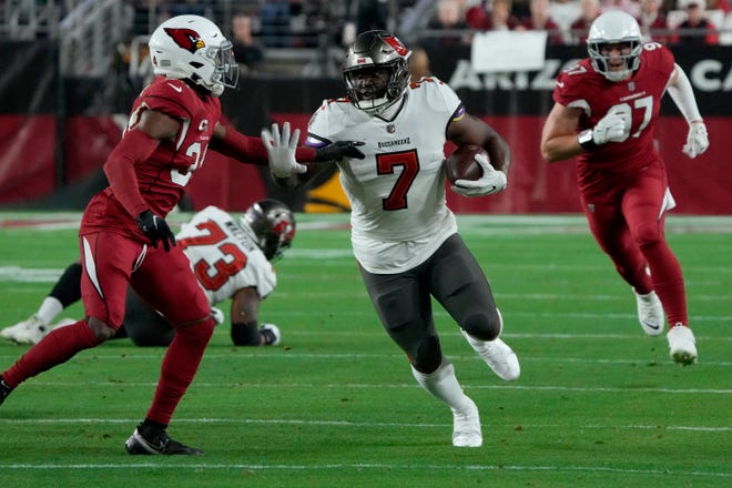 Tampa Bay Buccaneers running back Leonard Fournette (7) runs as Arizona Cardinals safety Jalen Thompson pursues during the first half of an NFL football game, Sunday, Dec. 25, 2022, in Glendale, Ariz. (AP Photo/Rick Scuteri)