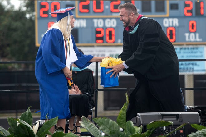Martin County High School graduate and government president Summer Reese gives Superintendent John Millay a gift during the commencement ceremony on Thursday, May 20, 2021, at the school in Stuart.