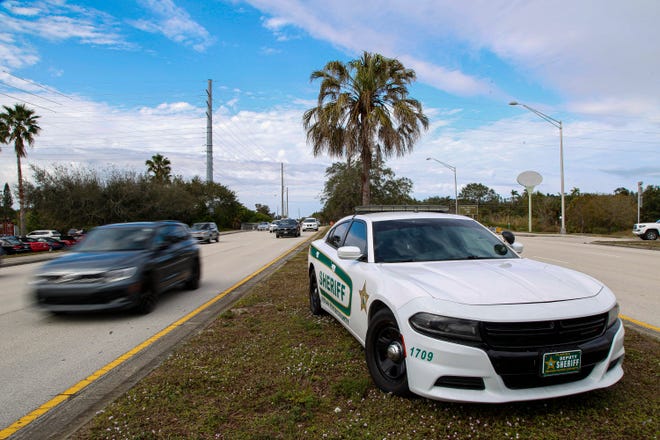 Southbound and northbound traffic along U.S. 1 near McKee Botanical Gardens in Indian River County pass a vacant Sheriff's Office patrol car parked in the center median on Monday, Jan. 23, 2023.