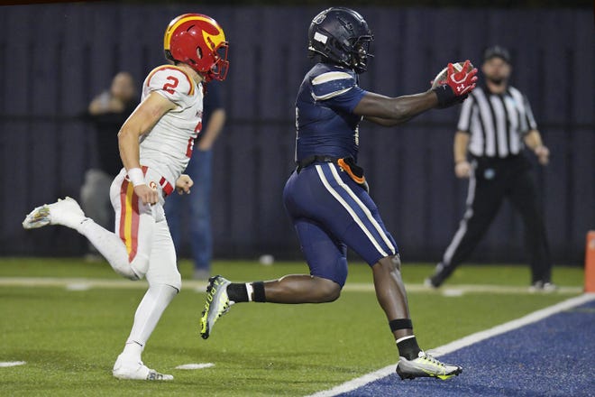 University Christian's Desirrio Riles (0)  stretches the ball over the goal line for a touchdown on a pass play during third quarter action while being defended by Clearwater Central Catholic's Andy Jaffe (2). The Clearwater Central Catholic Marauders traveled to Jacksonville, FL to take on the University Christian Christians in the Florida High School Athletic Association Class 1M starts football semifinal match Friday, December 2, 2022. The Marauders came away with a 29 to 34 win over the Christians. [Bob Self/Florida Times-Union]