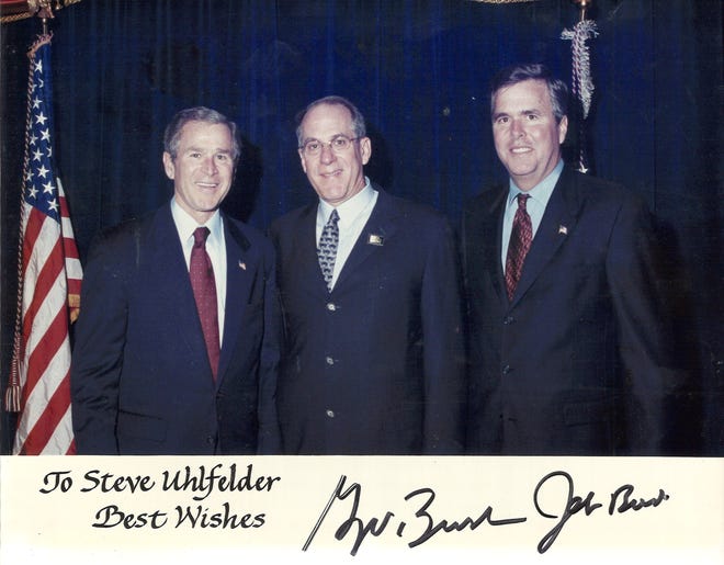 Steve Uhlfelder is appointed by President George W. Bush as chair of the Fulbright Scholarship Board, while Gov. Jeb Bush looks on.