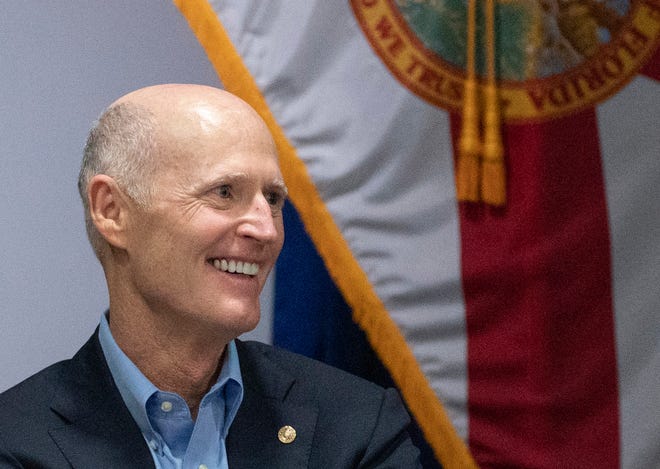 U.S. Senator Rick Scott, seen here at a roundtable discussion with local law enforcement leaders during a visit this month to the West Palm Beach Police station, is embroiled  in a political feud with President Joe Biden.