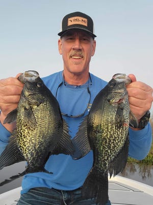 John Patterson, of DeLand, with a pair of speckled perch from a recent catch in Lake Woodruff.