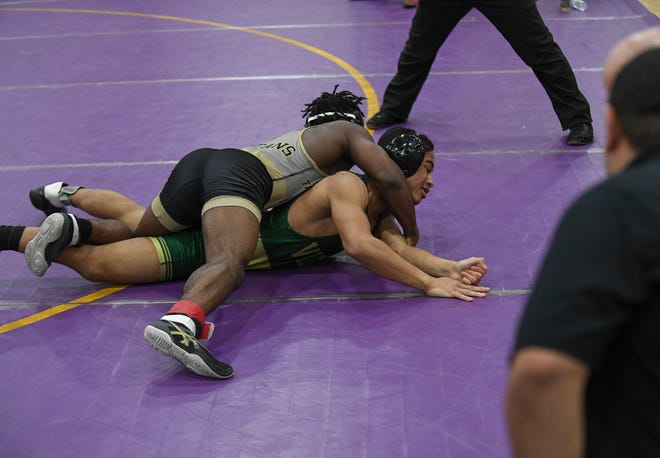 Brinalli Brown (top), of Treasure Coast High School, wrestles against Elan Bennett, of Viera High School, in their 138-pound championship match during the FLSAA Class 3A District 10 Championship boys wrestling at Fort Pierce Central gym on Friday, Feb. 17, 2023, in Fort Pierce. Brown won 138-pound championship match by pin.