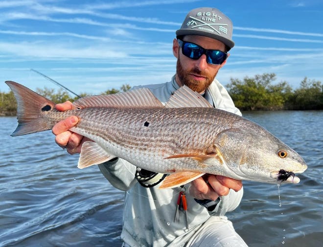 Jake Villwock with a catch-and-release red he caught while fly-fishing with Geno Giza.