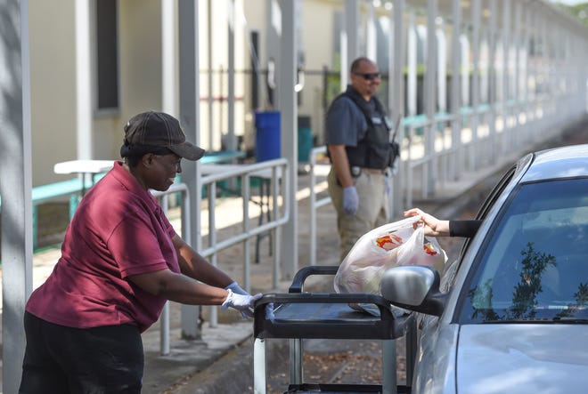 St. Lucie Public Schools staff help out assembling and distributing "Grab and Go" meals for school children at the C.A. Moore Elementary School bus loop on Monday, March 30, 2020, in Fort Pierce. The St. Lucie Public Schools Child Nutrition Services Department is serving the meals, including breakfast lunch, and dinner, with reheating instructions, for students in our community from 11:00 am to 1:00 pm, Monday through Friday, at participating schools during the COVID-19 pandemic. School staff will be on-site to pack and distribute the meals from the bus loops while following social distancing guidelines. Go go https://www.stlucie.k12.fl.us/ for the list of schools and more information on the program.