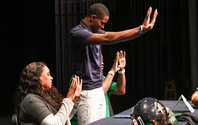 Eau Gallie football player Robert Stafford and his parents Robert Stafford and Tywanna Mack flash the “U” sign after he signed his college letters of intent in a ceremony Wednesday, December 21, 2022. Stafford will be playing for Miami. Craig Bailey/FLORIDA TODAY via USA TODAY NETWORK