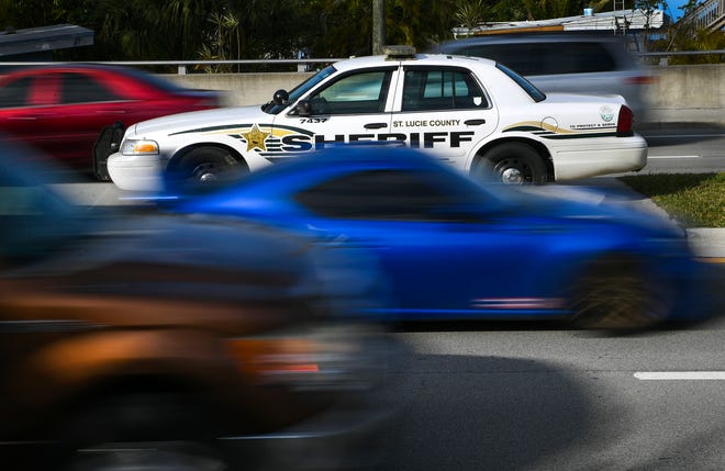 East and westbound Traffic along Midway Road travels past a vacant St. Lucie County Sheriff's Office Ford Crown Victoria patrol car parked in the center median across from White City Park on Tuesday, Jan. 24, 2023, in Fort Pierce. Law enforcement agencies are using vacant patrol vehicles as decoys to help prevent speeding in key locations.