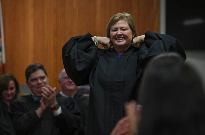 Newly appointed Circuit Judge Leatha Mullins gets a round of applause while putting on her judicial robe for the first time during the Investiture Ceremony for Mullins at the St. Lucie County Courthouse on Friday, Feb.24, 2023, in Fort Pierce.