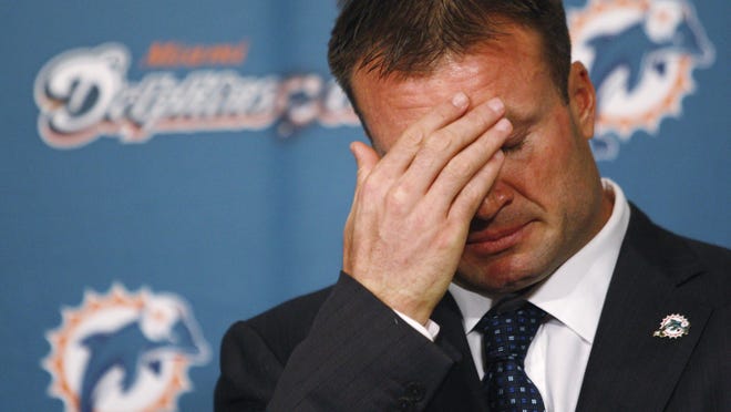 Zach Thomas fights back tears as he talks to the media during a news conference announcing his retirement. He signed a one-day contract to retire as a Dolphin in 2010.