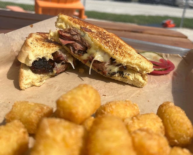 A new barbecue restaurant with outdoor-only seating features a brisket grilled cheese with gouda, caramelized red onion and barbecue sauce on its menu.