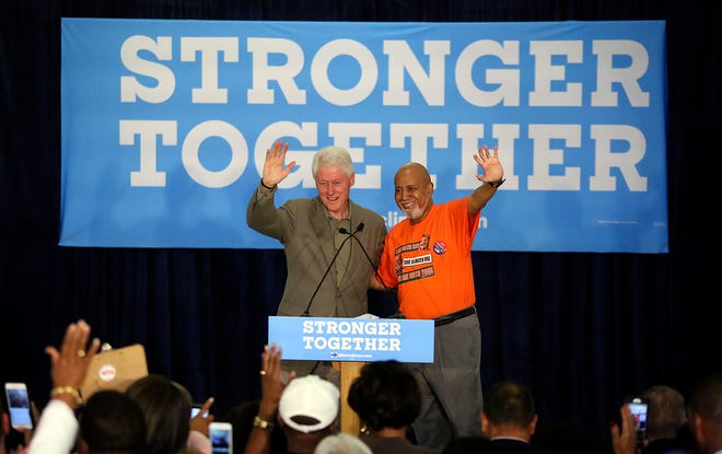 In this October 2016 image, former President Bill Clinton and the late U.S. Congressman Alcee Hastings wave to an audience at the Dolly Hand Cultural Arts Center in Belle Glade.