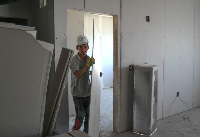 Construction crewman Andres Delgado works on placing drywall indside one of the 82 apartments in phase 1 of the Blue Sky Landing apartment complex on Monday Feb. 13, 2023, in Fort Pierce.