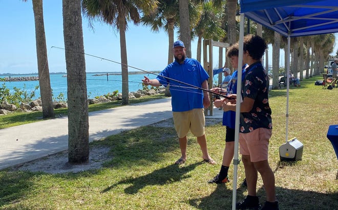 Capt. Bo Samuel of Pullin Drag charters in Fort Pierce shows students how to cast a fishing line on Feb. 23, 2023 in Memorial Park in Fort Pierce during the Chart Your Course program.