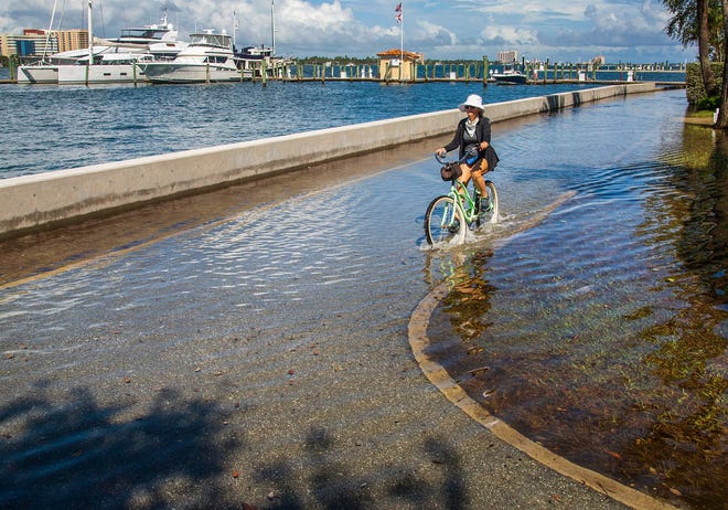 Water from the Intracoastal Waterway floods Lake Trail at Sunset Avenue in Palm Beach during high tide on October 20, 2020.  The flooding is the result of the yearly King Tides.
