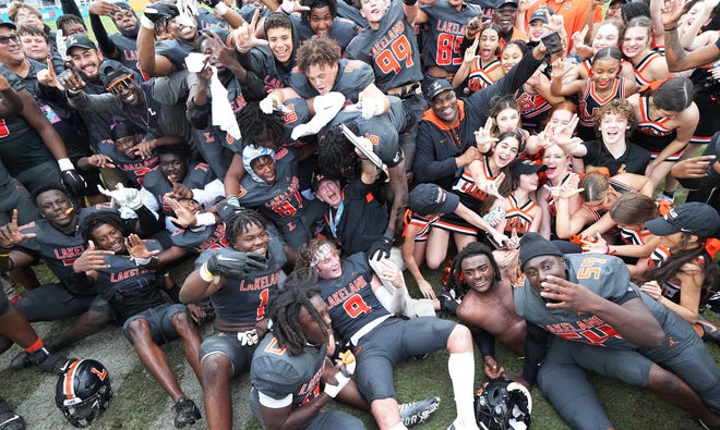 Lakeland head football coach William Castle (center) celebrates winning the Class 4S state championship game over Venice 21-14 with his team at DRV PNK Stadium, Saturday, Dec. 17, 2022 in Fort Lauderdale.