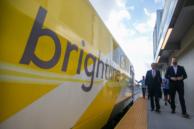 Boca Raton Mayor Scott Singer and Brightline President Patrick Goddard walk past a Brightline train parked at the new Brightline station during a tour on Tuesday, December 20, 2022, in Boca Raton.