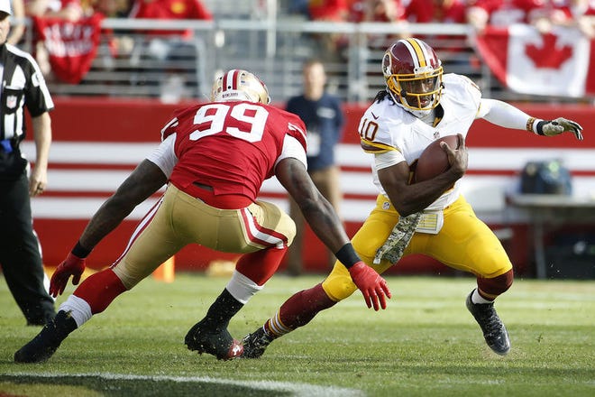 Washington Redskins quarterback Robert Griffin III (10) runs from San Francisco 49ers linebacker Aldon Smith (99) during the first quarter of an NFL football game in Santa Clara, Calif., Sunday, Nov. 23, 2014. (AP Photo/Tony Avelar)