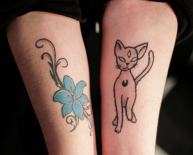 Benjamin, 16, a trans student in the Leon County Schools system, shows off his two tattoos. The flower is symbolic of their name before transitioning and the cat is a design he created himself.