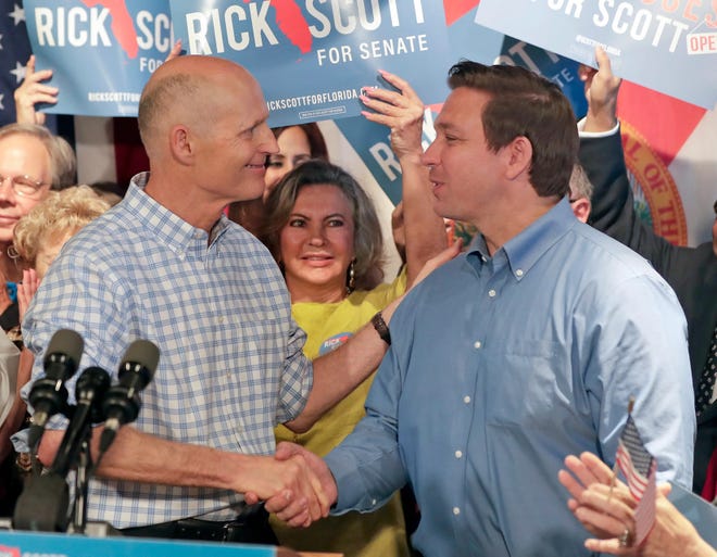 Florida Gov. Rick Scott, left, shakes hands with gubernatorial candidate Ron DeSantis as he introduces him to supporters at Republican rally Thursday, Sept. 6, 2018, in Orlando, Fla.