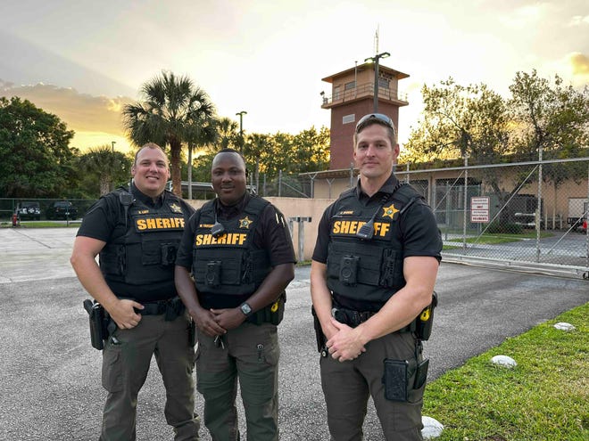 Deputies Brent Lavy (left), Wesnes Toussaint (center) and Cody Dionne (right) pose near the Martin County Sheriff's Indiantown substation. The three deputies saved a man from a partially submerged vehicle in Indiantown March 1, 2023.